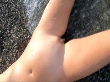 Chica rusa desnuda en la playa nudista en el Mar Negro