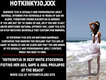 Hotkinkyjo en sexy medias blancas metiéndose el puño en el culo, boquiabierto y prolapso anal en la playa